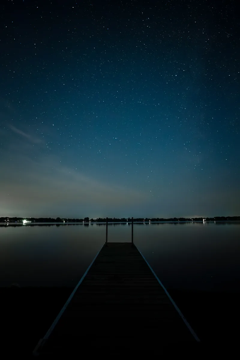 lake side pier at night with the a clear stary sky