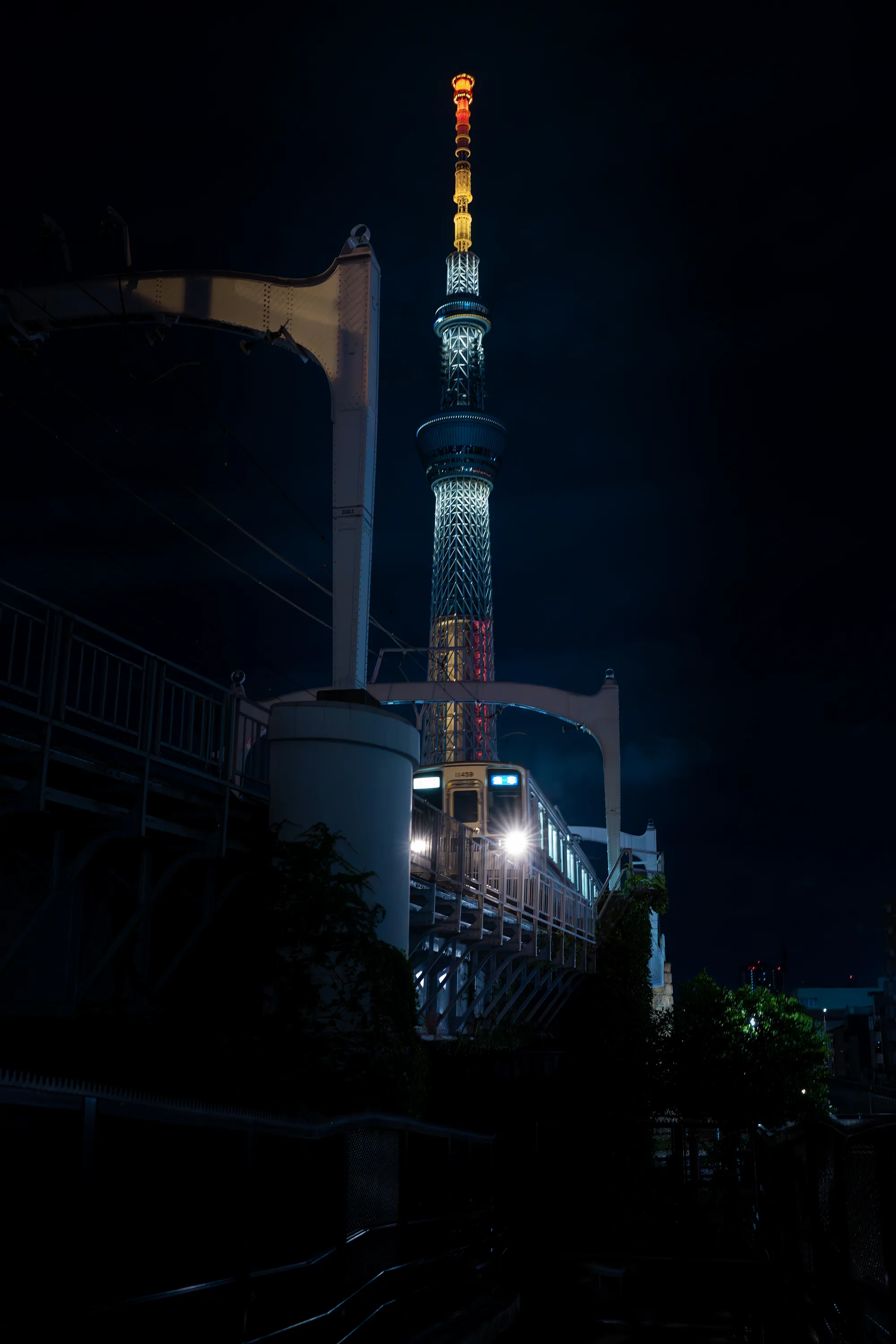train approching at night in front of the tokyo skytree