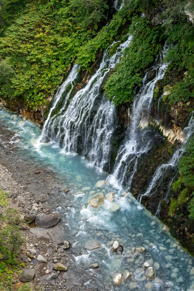 the blue waters of the shirahige waterfall in cental hokkaido near biei