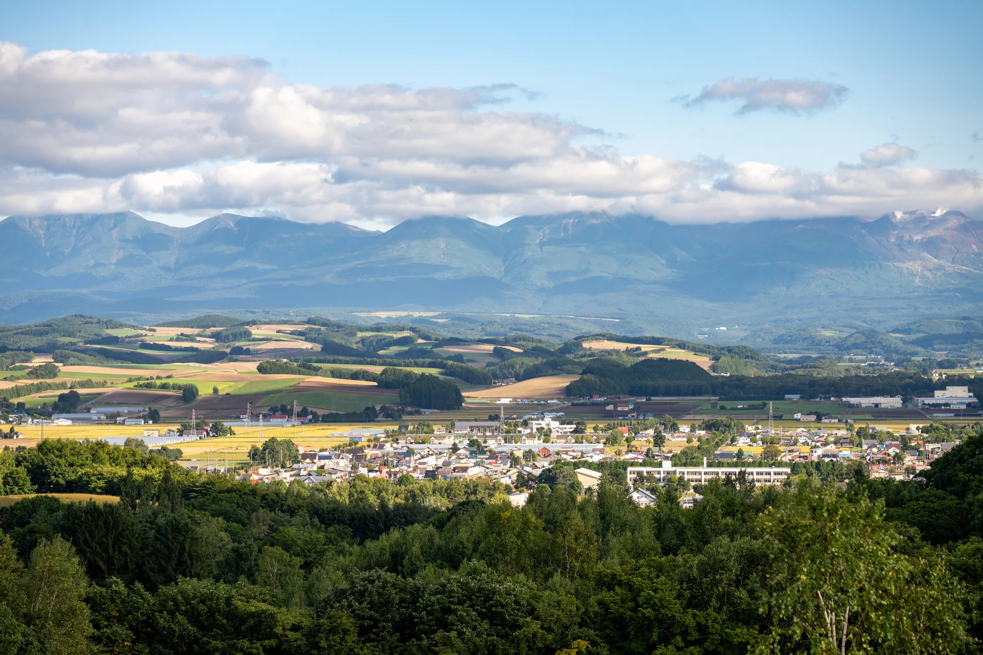view across the valley that biei japan is nestled in towards the daisetsuzan national park
