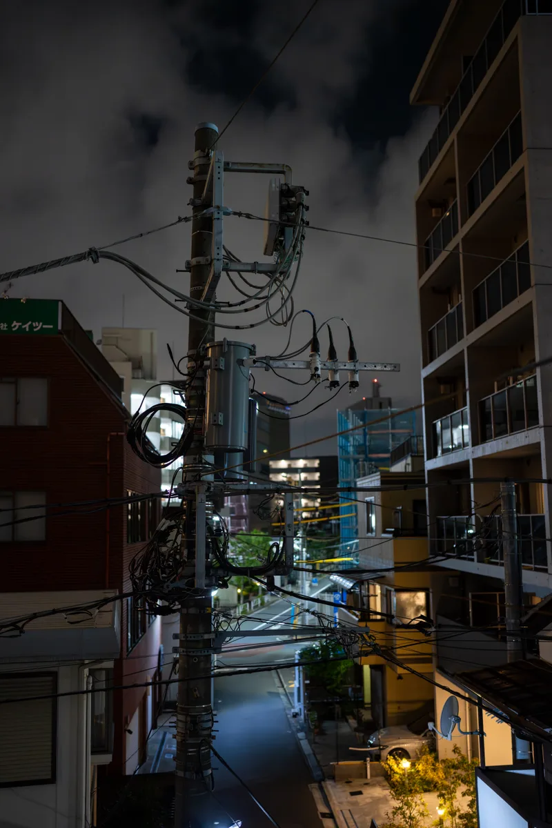 dimly lit power pole on a small street in central tokyo japan