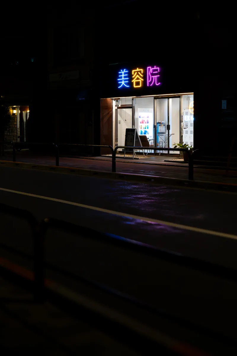 neon lights that read hair salon above a hair salon at night in central tokyo