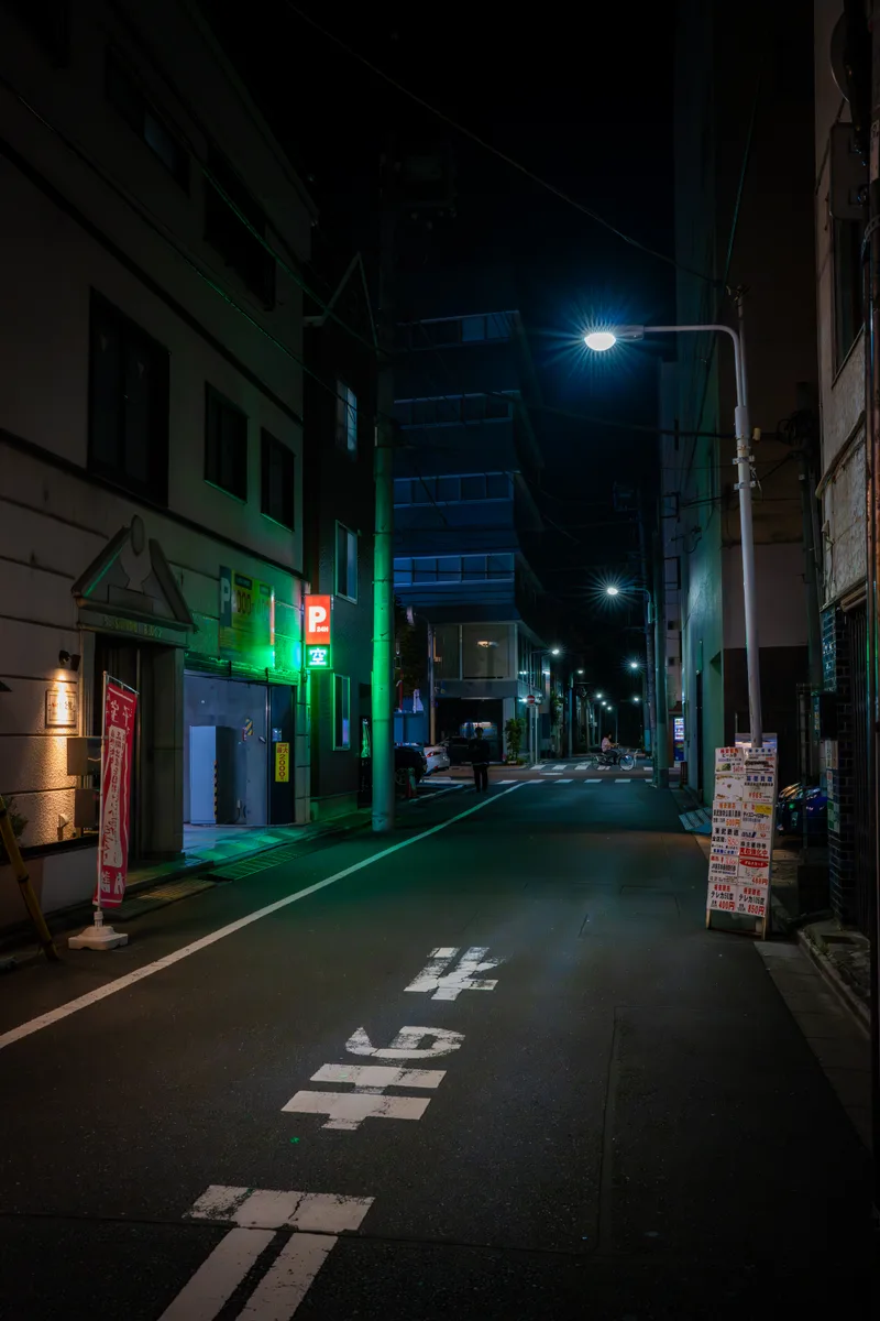 vacant parking sign illuminating a back street in central tokyo at night